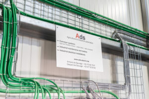Carte de visite d'Ads Electric au-dessus d'une de leurs réalisations